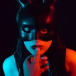 A sensual submissive woman with her Dominant's finger to her lip as he reads her quotes about submission.