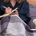 A woman journaling, reflecting on journal prompts for submissives.