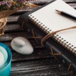 A BDSM journal on a table with a candle and other decorative elements.