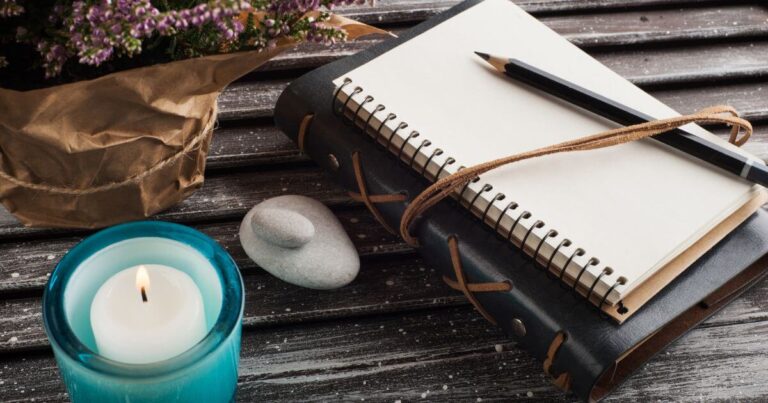 A BDSM journal on a table with a candle and other decorative elements.