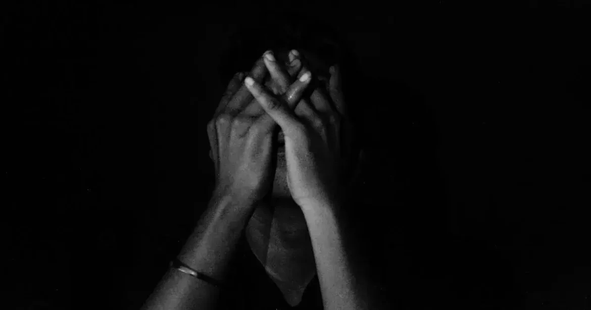 Dealing with Drop: Coping Strategies for Submissives and Dominants A person sitting in the darkness depressed and dealing with drop in BDSM.