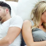 A couple navigating desire differences in BDSM in bed. They are unhappy.