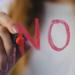 Safe words BDSM. Woman writing no on mirror in lipstick.