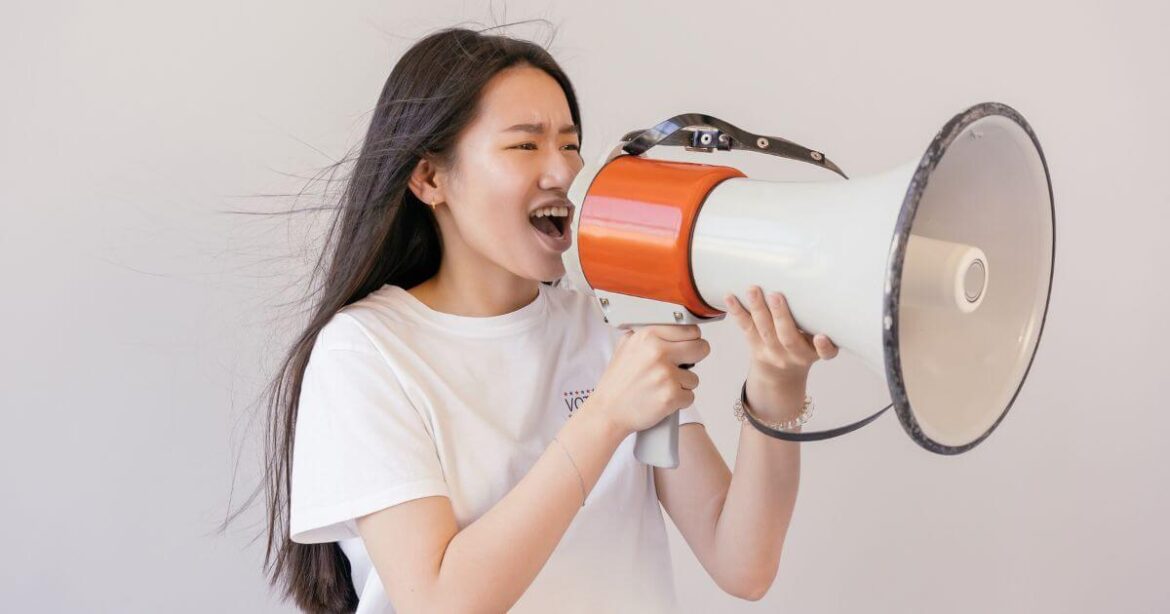 Finding Your Dominant Voice: Speak with Confidence in Any Scene A woman speaking with her dominant voice into a megaphone.