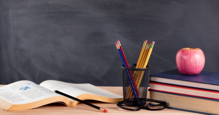 How to Vet a BDSM Educator or Class Before You Sign Up A school setting with a chalkboard, apple, pencils, and books. The theme is vet a BDSM educator